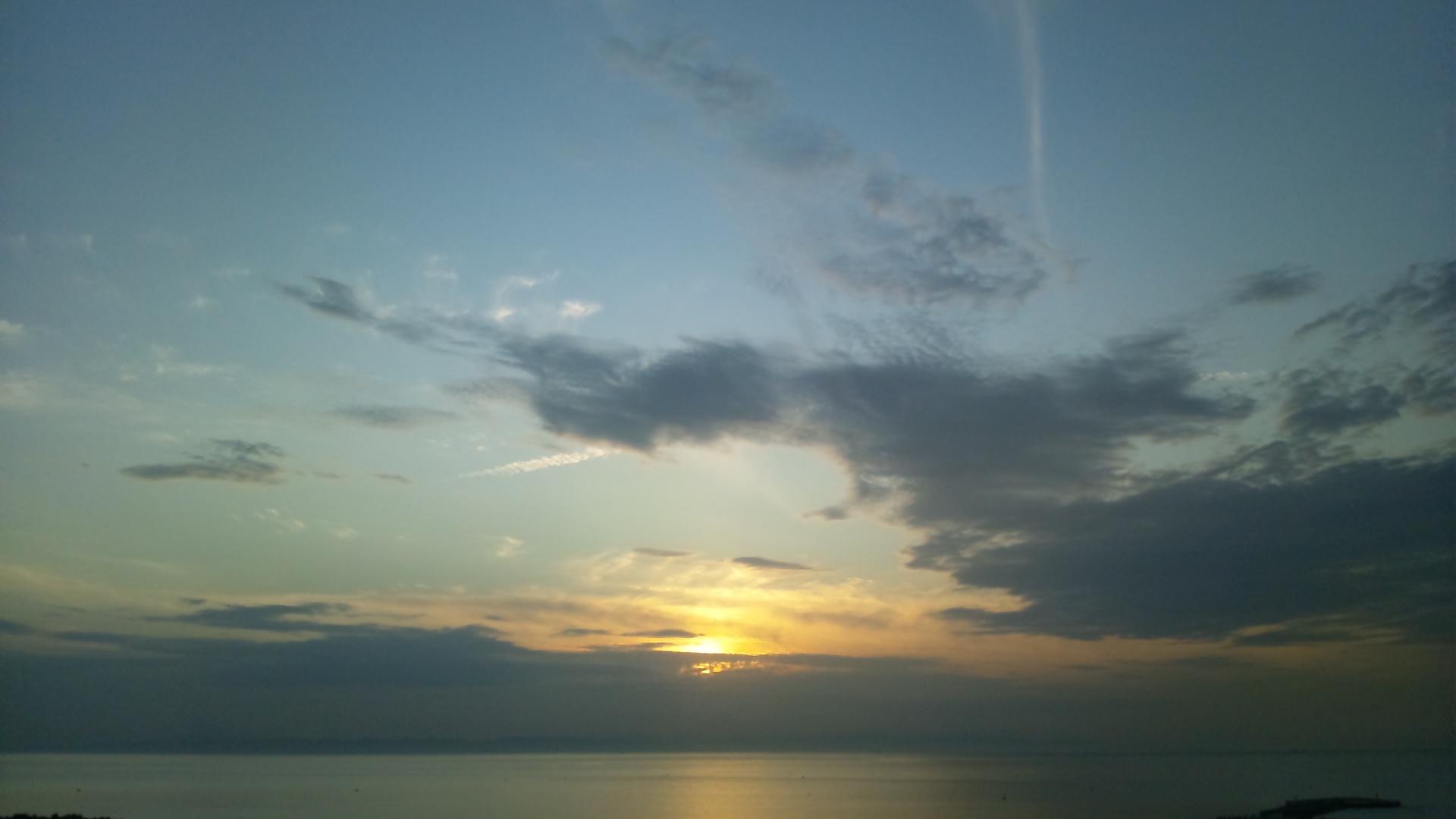 夕日と飛行機雲の無料写真